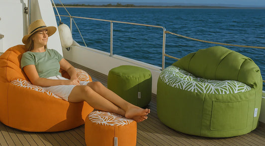 Woman relaxing on a boat with orange and green bean bags and ottomans.
