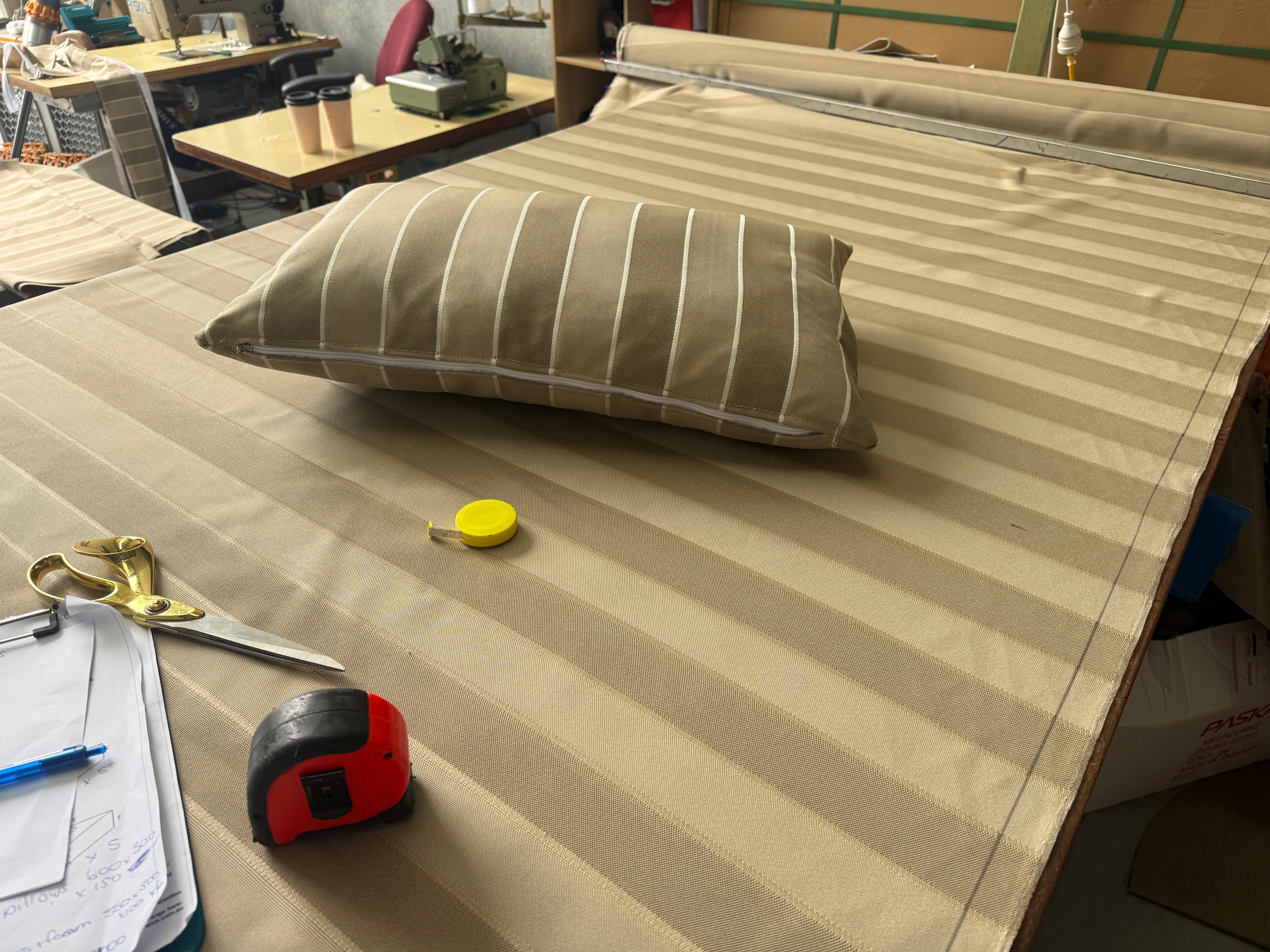beige-white-striped-bed-frame-mattress-topper-workshop-tools-pillow-scissors-tape-measure-marker.jpg