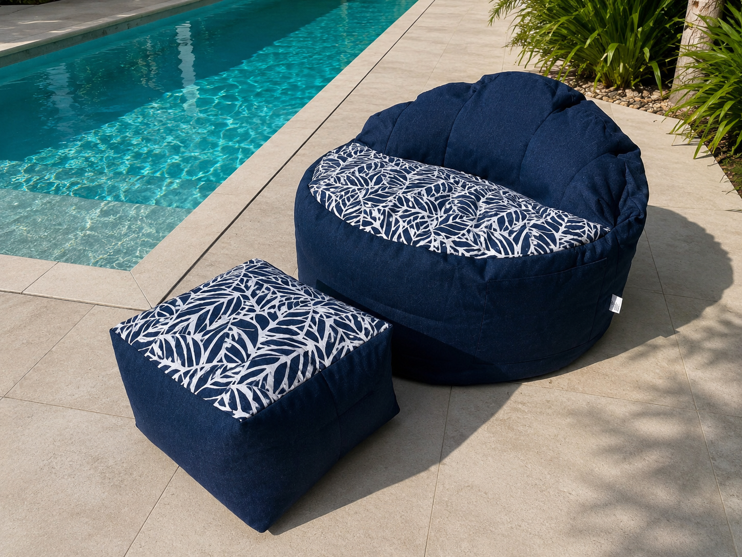Navy bean bag chair and ottoman with leaf pattern by a pool