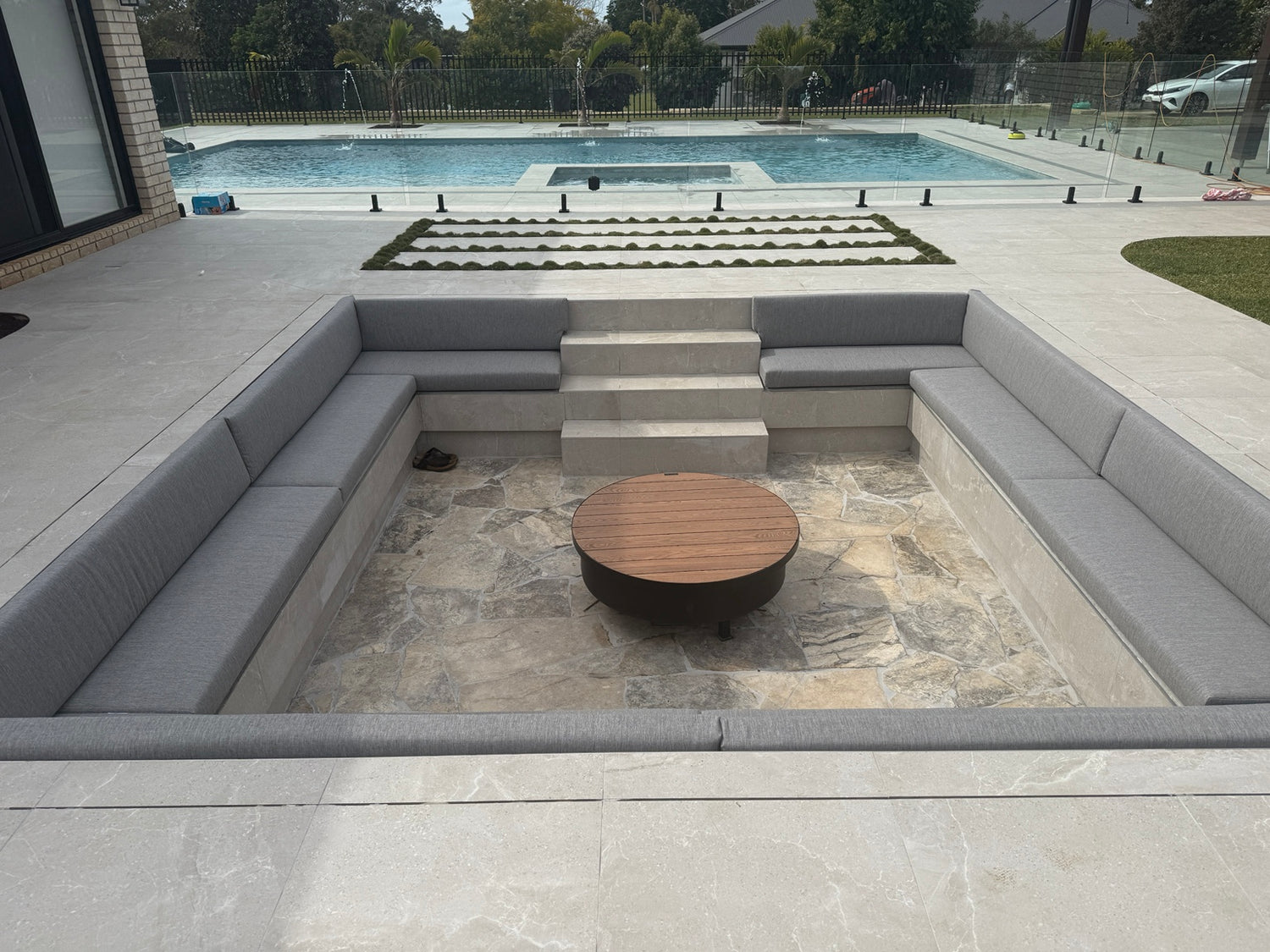 Outdoor seating area with a fire pit table near a pool