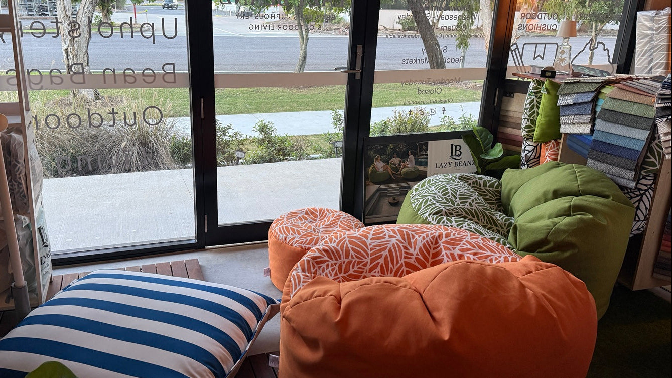 Living room with bean bags and cushions near a large window with outdoor view