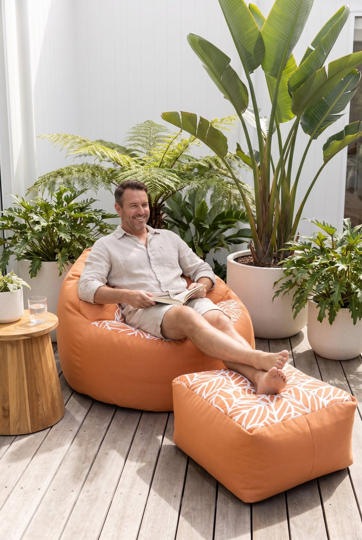 Lazy Beanz Coral Reef Orange adult outdoor bean bag and square ottoman in a tropical outdoor setting