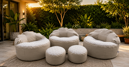 Custom beige outdoor bean bags and matching ottomans in a landscaped patio setting