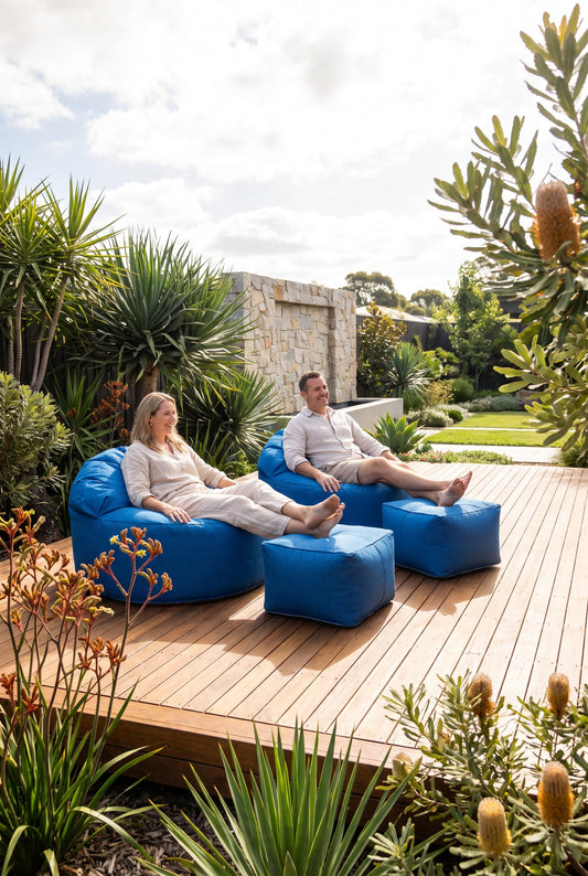 Couple relaxing on custom blue outdoor bean bags with matching ottomans