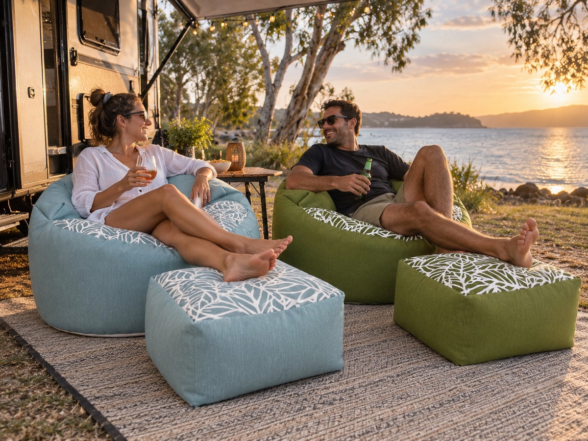 Couple relaxing on Lazy Beanz blue and green bean bag sets at a waterfront caravan campsite