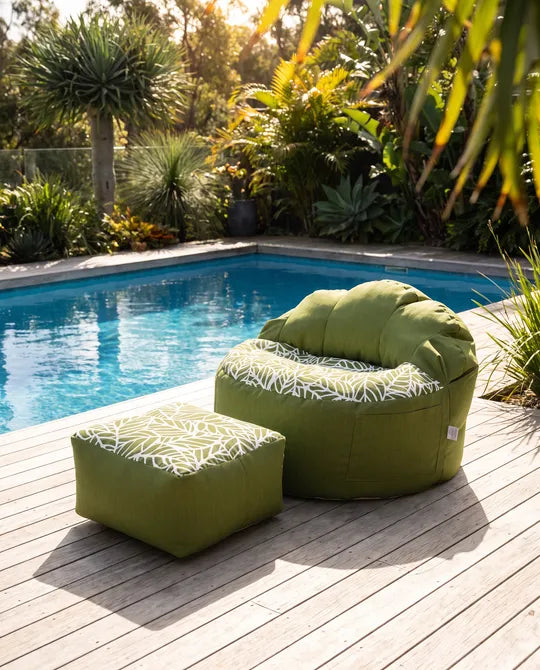 Lazy Beanz Island Palm Green adult bean bag and square ottoman beside a swimming pool