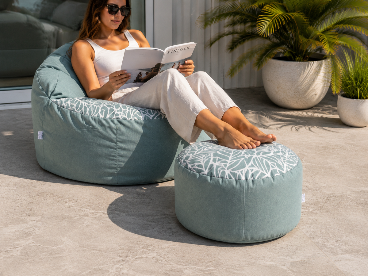 Woman relaxing outdoors on a Lazy Beanz Ocean Breeze adult bean bag and small round ottoman set