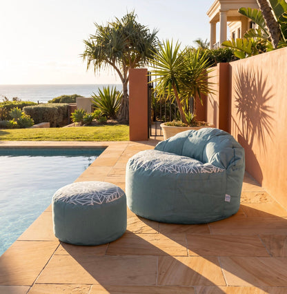 Lazy Beanz Ocean Breeze adult bean bag and round ottoman beside a swimming pool