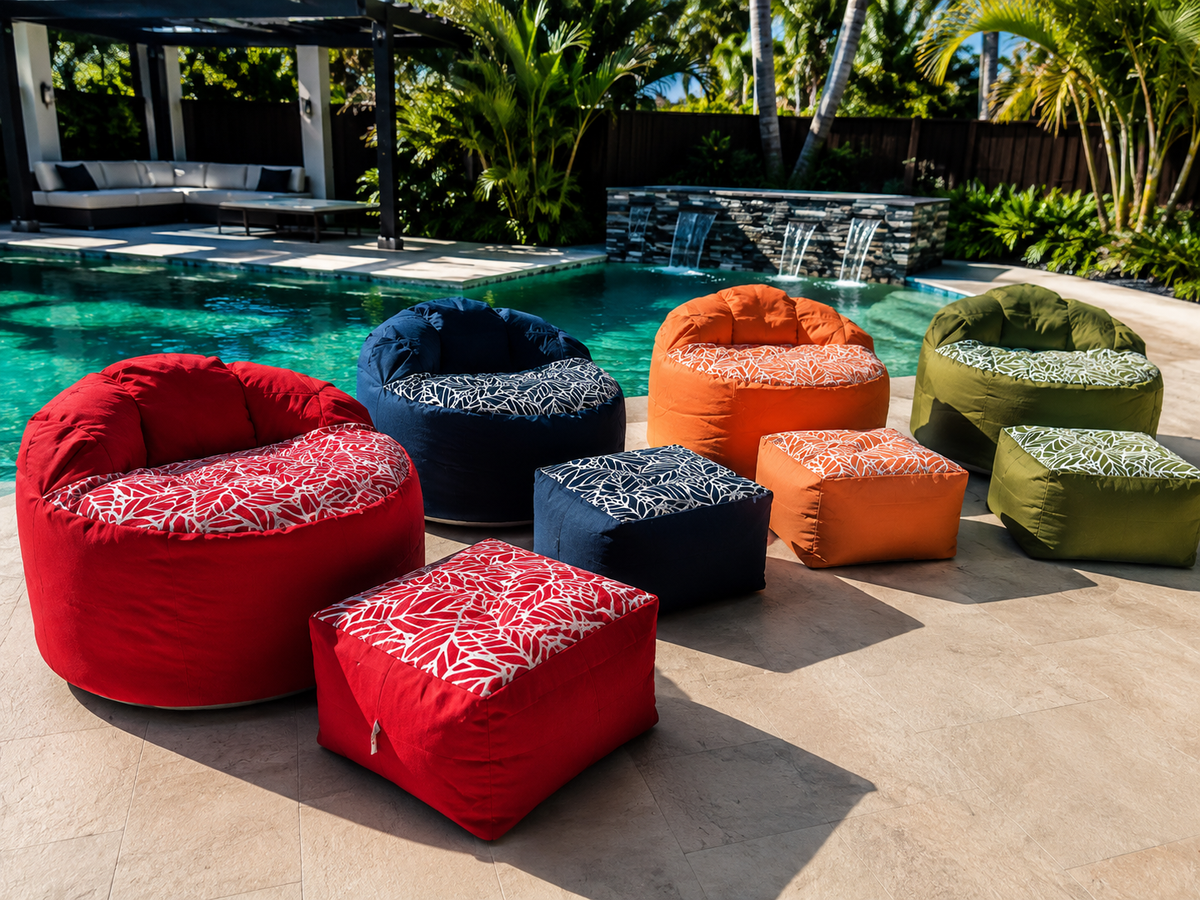 Lazy Beanz adult outdoor bean bags and matching ottomans in four colours arranged beside a swimming pool