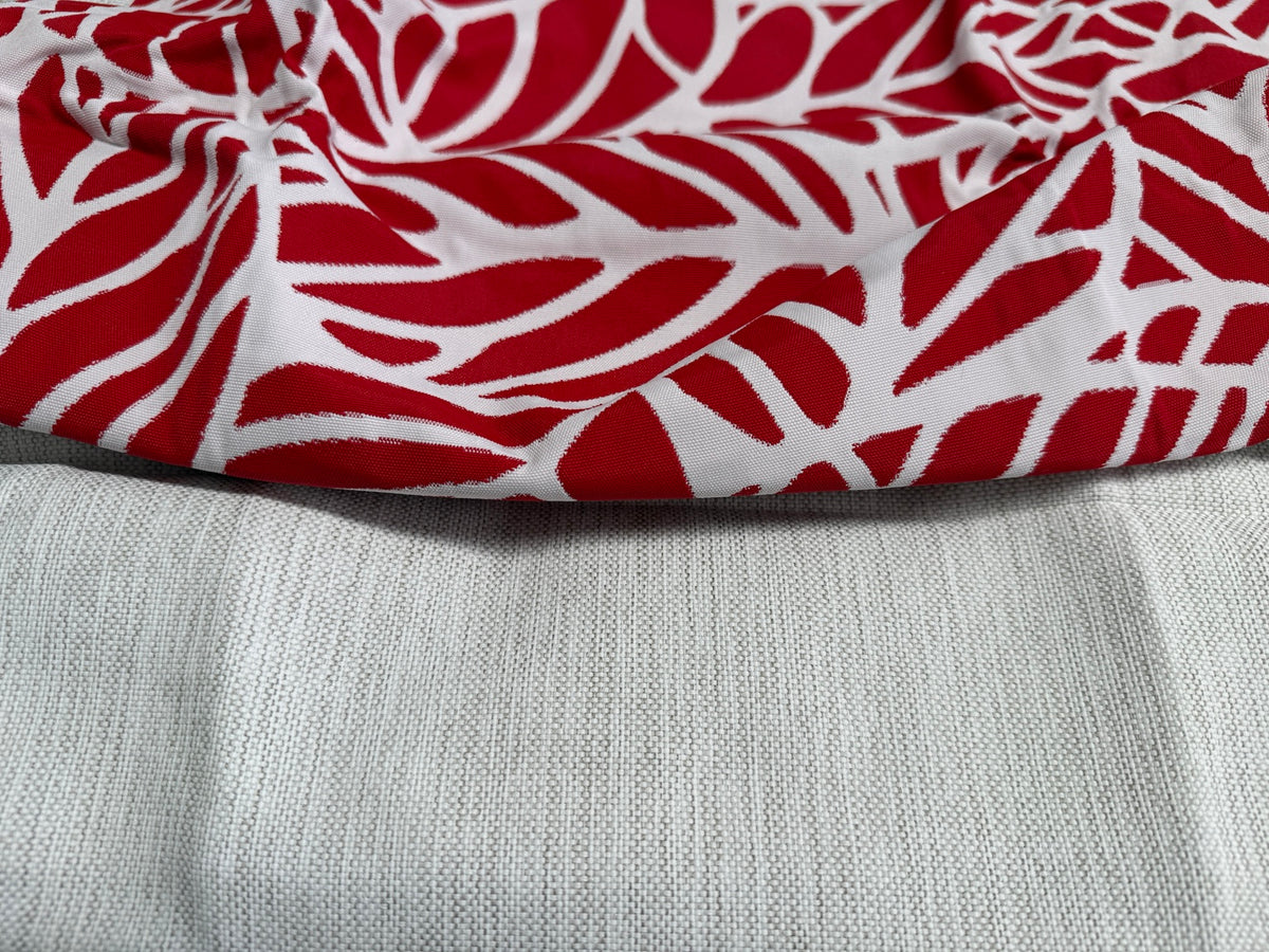 Fabric close-up: Lomani Cloud and red Lobster tropical leaf fabric for limited-batch small square ottoman